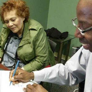 man signing document with woman watching